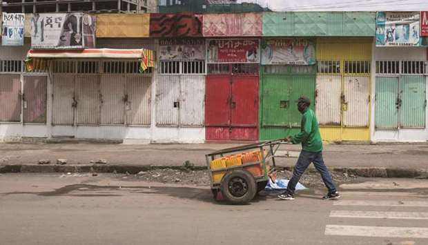 A man pushes a hand-cart past closed shops following protests in Addis Ababa, Ethiopia, yesterday.