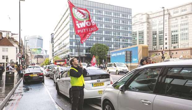 A protesting Uber driver waves a flag near the UK headquarters of Uber Technologies in London (file).