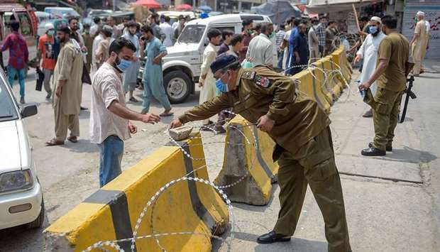 Policemen put barbed wire as a market area is sealed by the authorities in Rawalpindi yesterday, as Covid-19 coronavirus cases continue to rise.