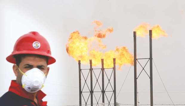 Flames emerge from flare stacks at Nahr Bin Umar oilfield, as a worker wears a protective mask, following an outbreak of coronavirus, north of Basra, Iraq (file). Southern Iraqi  exports in the first 20 days of July averaged 2.70mn bpd, according to the average of figures from Refinitiv Eikon and two industry sources.
