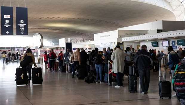 Travellers queue at the Ailitalia and Air France-KLM flight check in desks as European Union travel restrictions are lifted at Charles de Gaulle Airport in France.