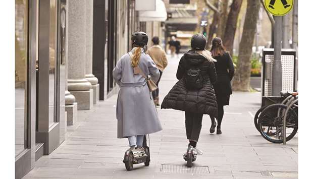 Two shoppers on scooters make their way down the normally busy shopping precinct of Collins Street in Melbourne yesterday.