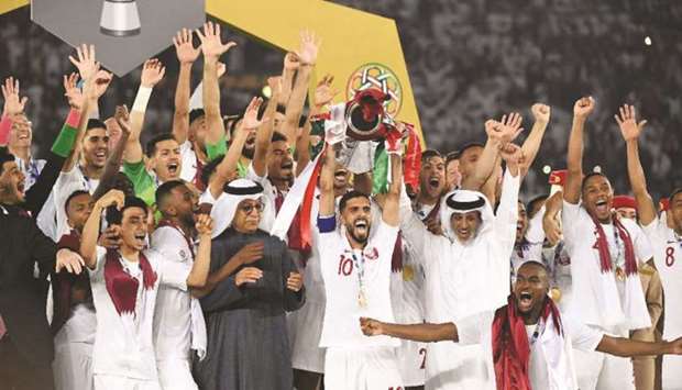 In this February 1, 2019, picture, Qataru2019s players celebrate with the trophy in the presence of QFA President HE Sheikh Hamad bin Khalifa bin Ahmad al-Thani and AFC President Sheikh Salman bin Ebrahim al-Khalifah after winning the 2019 AFC Asian Cup in Abu Dhabi.