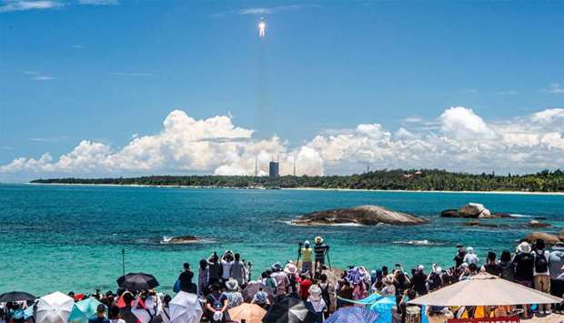 People watch a Long March-5 rocket, carrying an orbiter, lander and rover as part of the Tianwen-1 mission to Mars, lifting off from the Wenchang Space Launch Centre in southern China's Hainan Province, China.