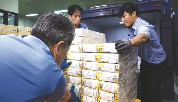 Workers move bundles of South Korean 50,000 won banknotes into a truck at the Bank of Koreau2019s Gangnam office in Seoul (file). The economy shrank by a seasonally adjusted 3.3% in the June quarter from three months earlier, the Bank of Korea said yesterday.