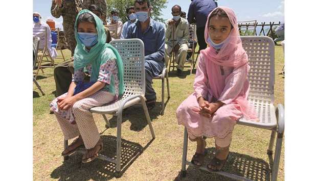 Faiza (left) and Sheerat Shabbir, who are sisters and got shrapnel wounds when a shell hit their family house, sit along with other villagers and journalists during a trip organised by the army, near the Line of Control (LoC) in Chirikot Sector, Kashmir.