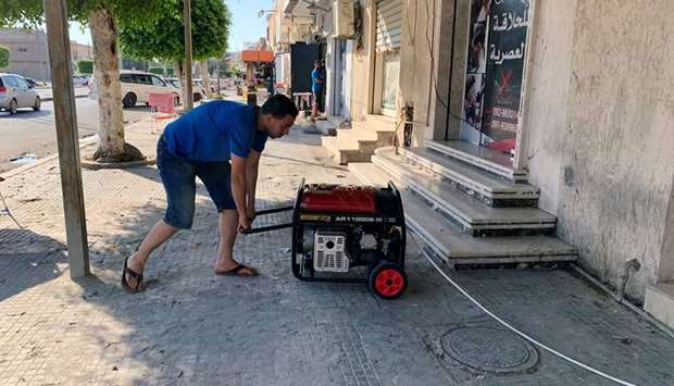 A barber prepares his generator at his shop during the long-lasting power blackouts, in Misrata.