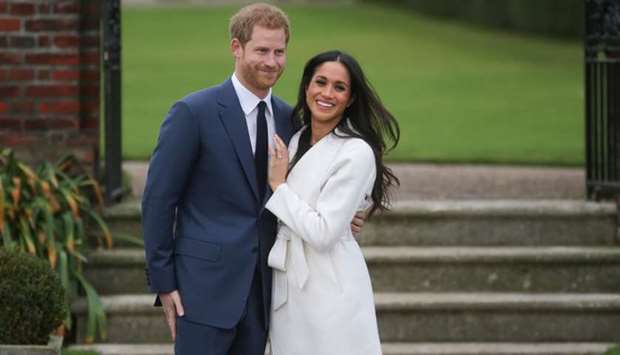 In this file photo taken on November 27, 2017 Britain's Prince Harry and his fiancu00e9e US actress Meghan Markle pose for a photograph in the Sunken Garden at Kensington Palace in west London