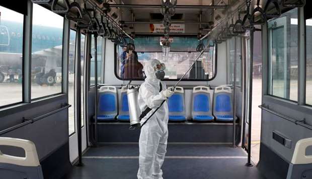A health worker sprays disinfectant inside a bus to protect from the recent coronavirus outbreak in Hanoi, Vietnam 