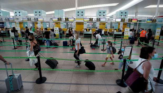 Passengers queue at a Vueling check-in desk at Josep Tarradellas Barcelona-El Prat airport, amid the spread of the coronavirus disease, in Barcelona, Spain
