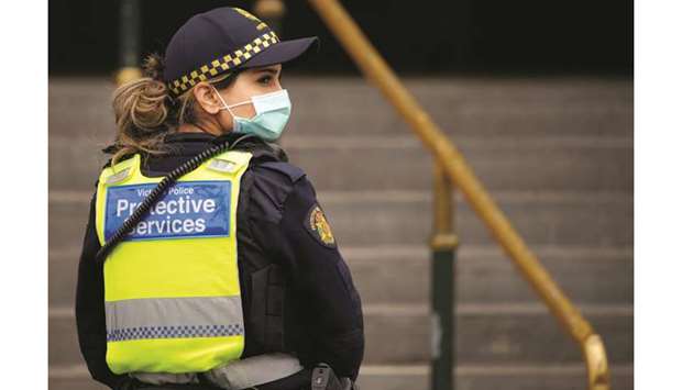 A Protective Services Officer wearing a face mask patrols Flinders Street station in Melbourne after it became the first city in Australia to enforce mask-wearing in public as part of efforts to curb a resurgence of the coronavirus disease (Covid-19).
