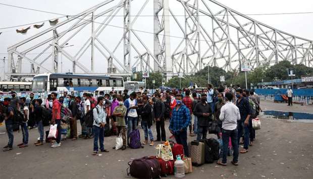Migrant workers wait in lines for transport outside the Howrah railway station after authorities announced lockdown for two days every week in the West Bengal state, amidst the spread of the coronavirus disease in Kolkata