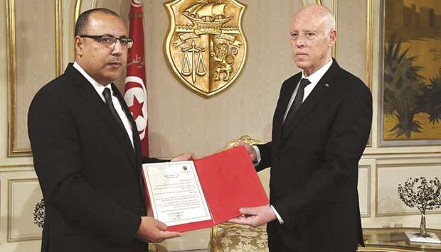 In this handout picture provided by the Tunisian Presidency Press Service, President Kais Saied appoints Interior Minister Hichem Mechichi (left) as the countryu2019s new prime minister, at the Carthage Palace on the eastern outskirts of the capital Tunis.
