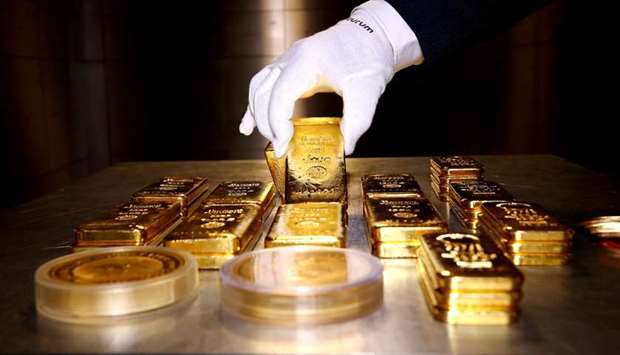 Gold bars and coins are stacked in the safe deposit boxes room of the Pro Aurum gold house in Munich, Germany (file). At the close of trading in New York on Friday, bullion spiraled to $1,902.02 an ounce, some 30% higher than the low it hit in March and just 1% off a record high set back in 2011.