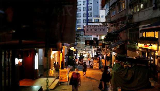 People wearing protective face masks walk at Mid-Levels Central, following the coronavirus disease (COVID-19) outbreak in Hong Kong