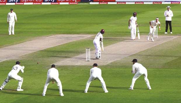 West Indiesu2019 Kemar Roach (C) looks behind as Englandu2019s Jos Buttler (L) catches him out off the bowling of Englandu2019s Stuart Broad (R) on the third day of the third Test cricket match at Old Trafford in Manchester yesterday.