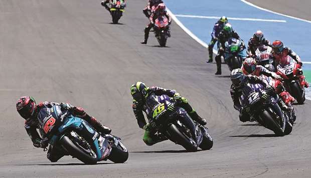Petronas Yamaha SRTu2019s French rider Fabio Quartararo (L) leads the MotoGP race during the Andalucia Grand Prix at the Jerez race track in Jerez de la Frontera yesterday. At bottom, he celebrates on the podium.