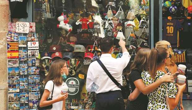People look at masks displayed at a souvenir shop, amid the coronavirus disease outbreak, in Barcelona, Spain.