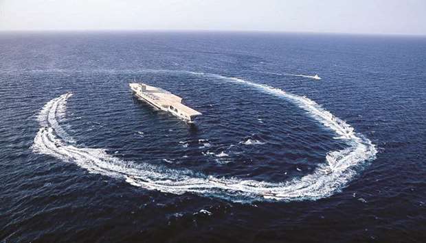 This handout photo provided by Iranu2019s Revolutionary Guard Corps (IRGC) official website via SEPAH News yesterday shows an Iranian mockup imitating a US aircraft carrier being encircled by speedboats during a military exercise near the Strait of Hormuz.