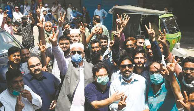 Traders gesture as they protest beside their closed shops against a lockdown imposed by the Punjab provincial government in an effort to curb the spread of the Covid-19 coronavirus ahead of Eid al-Adha, in Lahore yesterday.
