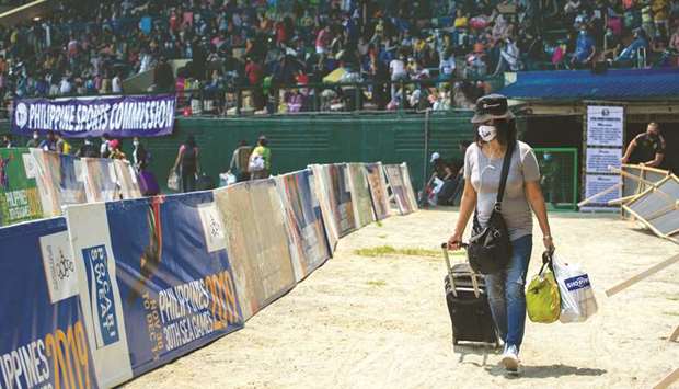 Photo taken on July 25, 2020 shows a woman walk to get a Covid-19 rapid test in a baseball stadium, where Filipinos stranded due to the coronavirus restrictions are gathered before being transported back to their provinces through a government transportation programme, in Rizal Memorial Sports Complex, Manila.