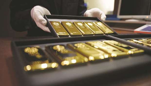 An employee displays one-kilogram gold bars at a store in Tokyo. Citing data published by the World Gold Council, Malabar Gold said many central banks have continued to invest in gold and have increased their holdings in the last three to nine months.