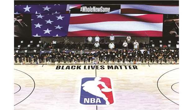 Members of the New Orleans Pelicans and Utah Jazz kneel together around the Black Lives Matter logo on the court during the US national anthem before the start of their NBA game at The Arena at ESPN Wide World Of Sports Complex in Lake Buena Vista, Florida, on Thursday.  PICTURE: USA TODAY Sports