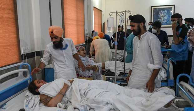Sikh people gather around injured victims treated at a hospital following the accident between a train and a van transporting Sikh pilgrims in Sheikhupura district of the Pakistan's Punjab province on July 3, 2020. At least 19 Sikh pilgrims -- all from the same family - were killed on July 3 when a train smashed into a van in the east of Pakistan, officials said