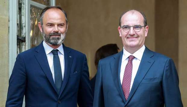 Former French Prime Minister Edouard Philippe (L) stands with newly-appointed Prime Minister Jean Castex on the steps of the Matignon Hotel in Paris