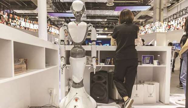 An attendant stands next to a CloudMinds Technology XR-1 commercial humanoid service robot at the World Artificial Intelligence Conference in Shanghai. The services sector accounts for about 60% of the Chinese economy and half of the urban jobs, and includes many small, private companies which had been slower to recover initially than large manufacturers.