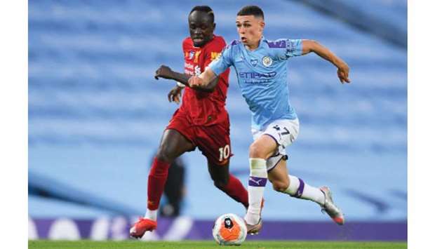 Manchester Cityu2019s midfielder Phil Foden (right) vies for the ball with Liverpoolu2019s striker Sadio Mane during the Premier League match in Manchester on Thursday. (AFP)