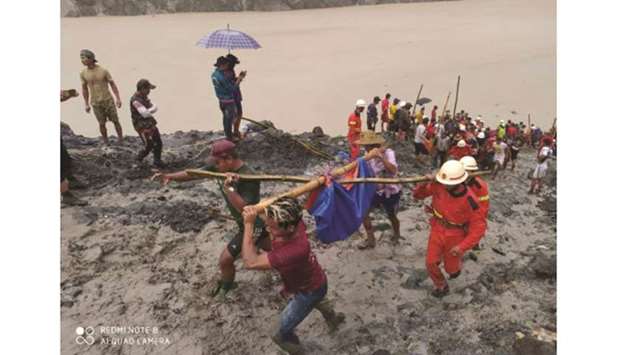 People carry a dead body at the  mining site in Hpakant, Kachin, Myanmar.