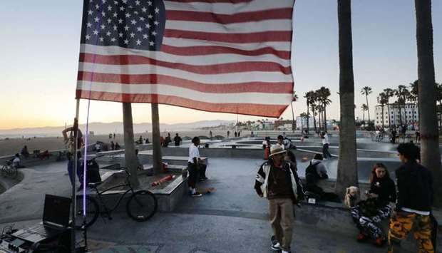 An American flag flies as people gather at Venice Skate Park, which remains open along the closed and mostly empty Venice Beach, amid the Covid-19 pandemic on July 3, in Venice, California