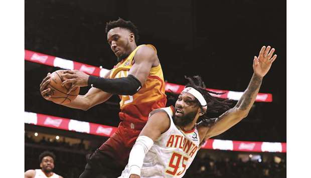 Utah Jazz guard Donovan Mitchell (left) grabs a defensive rebound over the Atlanta Hawksu2019 DeAndre Bembry during a regular NBA game at State Farm Arena in Atlanta on December 19, 2019. (TNS)