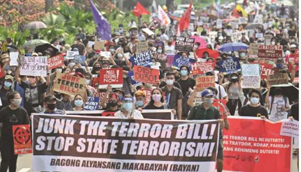File photo taken on June 4, 2020 shows mask-clad protesters marching against an anti-terrorism bill at a university campus in Manila. President Rodrigo Duterte has signed a contentious anti-terrorism bill into law that critics fear will be used to silence dissent.