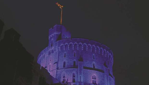 The Round Tower at Windsor Castle, where Queen Elizabeth is living due to the coronavirus pandemic, is pictured illuminated blue late on Friday to mark the 72nd anniversary of the NHS today.