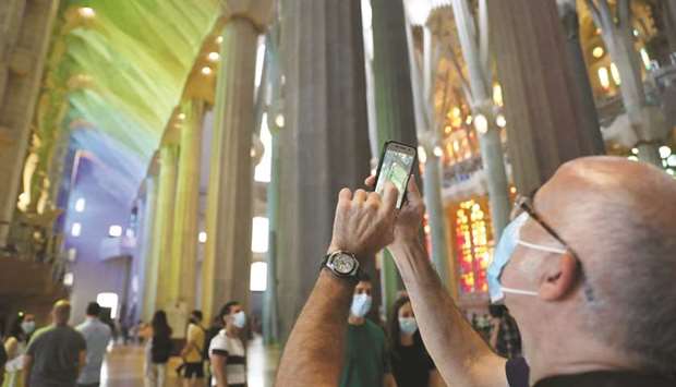 A man uses his phone as health workers, police officers and NGO staff members with their families visit the Sagrada Familia basilica in Barcelona.