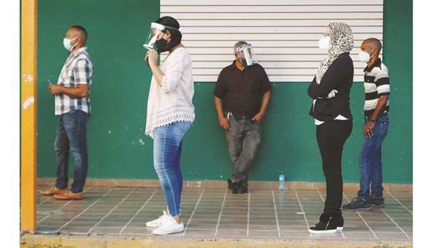People wearing protective masks stand in line to cast their votes in the general election during the outbreak of the coronavirus disease in Santiago, Dominican Republic, yesterday.