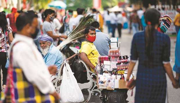 A vendor wearing a face masks waits for customers for his beauty products in a market area in New Delhi yesterday.