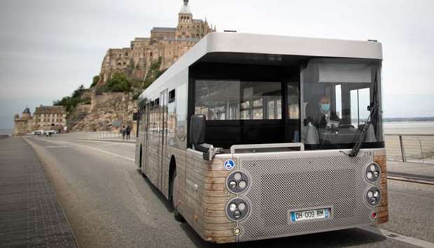 A driver wearing a protective mask sits in a shuttle bus in front of ,Le Mont-Saint-Michel,, in Normandy, northwestern France. Photo: AFP