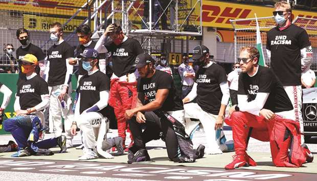 Mercedesu2019 Lewis Hamilton, Ferrariu2019s Sebastian Vettel and other drivers kneel on the grid wearing an anti-racism T-shirt before the race yesterday.