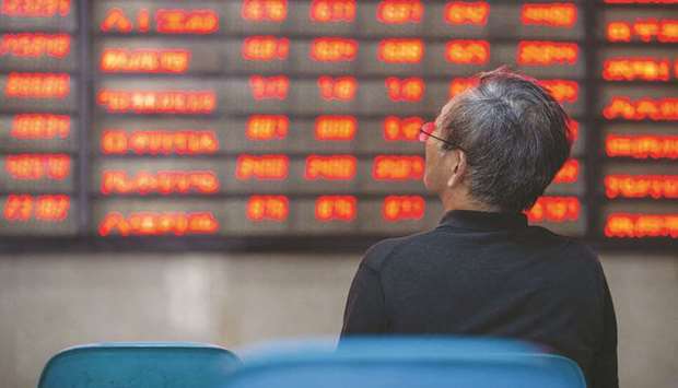 An investor looks at screens showing stock market movements at a securities company in Nanjing in Chinau2019s eastern Jiangsu province. Shanghai stocks surged 5.7% to 3,332.88 points yesterday as investors piled in following a combination of rosy predictions for the market and strong economic data.