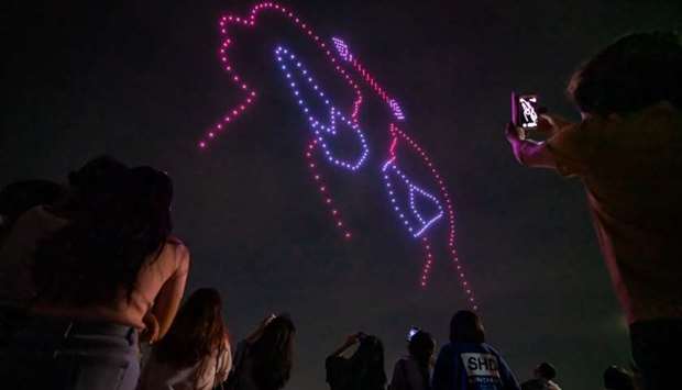 People taking photos of a drone display showing messages of support for the country amid the covid-19 pandemic, above the Han river in central Seoul. AFP/South Korea's Ministry of Land, Infrastructure, and Transport.