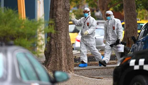 People in hazardous material overalls are seen outside of a public housing tower along Racecourse Road that was placed under lockdown due to the coronavirus disease outbreak in Melbourne.