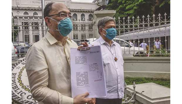 Law professor Howie Calleja (left) and Armin Luistro, former education secretary, stand outside the Supreme Court after filing a petition to challenge the constitutionality of an anti-terror law in Manila, yesterday.