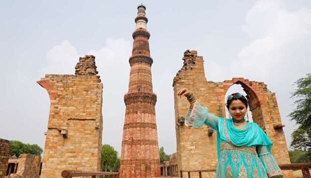 A woman poses for a picture in front of Qutub Minar after authorities reopened the monument for visitors following a three-month lockdown in New Delhi yesterday.