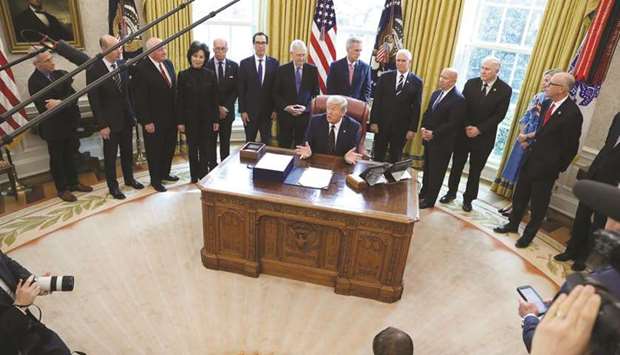 US President Donald Trump signs the $2.2tn HR 748 CARES Act coronavirus aid package bill in the Oval Office of the White House in Washington, US, on  March 27, 2020.