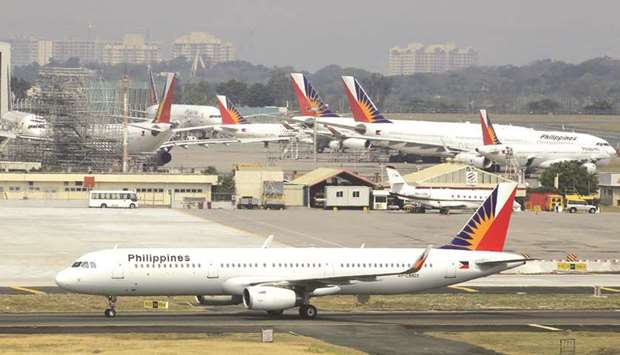 File photo shows an aircraft of Philippines Airlines (PAL), the southeast Asian nationu2019s flag carrier, taxiing at a runway while other aircraft are parked besides the hangar of the airport in Manila.