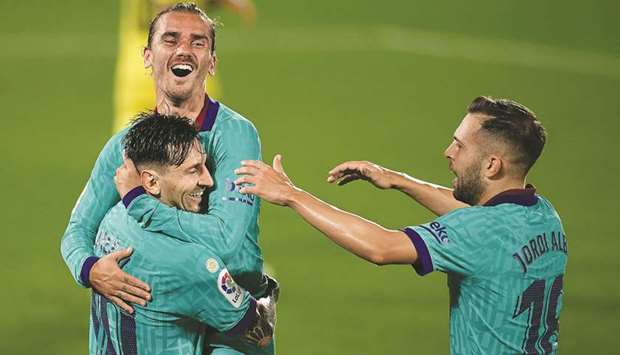 Barcelonau2019s Antoine Griezmann (centre) celebrates with Lionel Messi and Jordi Alba (right) after scoring against Villarreal in the La Liga at the Madrigal stadium in Villarreal, Spain, on Sunday night. (AFP)