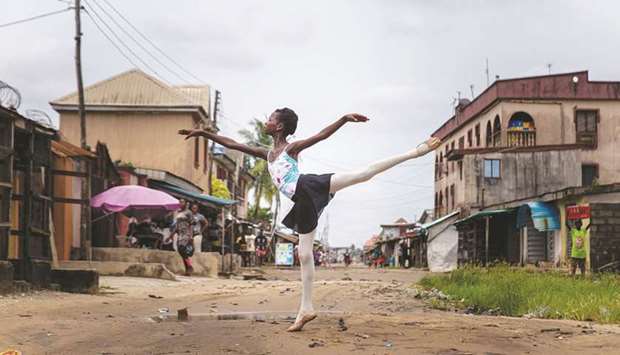 Leap of Dance Academy student Precious Duru performs a dance routine in Okelola street in Ajangbadi, Lagos.